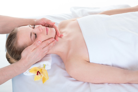 Young woman receiving head massage by masseur at health spaの写真素材