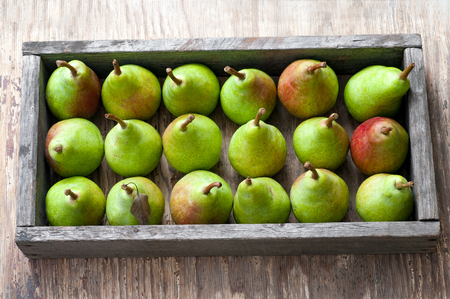 Wooden box with perfectly formed ripen pears. Old wooden backgroundの写真素材
