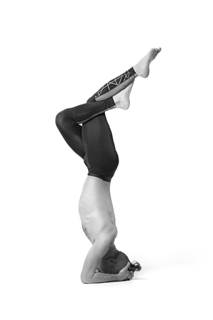 Muscular handsome young man working out, yoga, pilates, fitness training, doing handstand, profile...