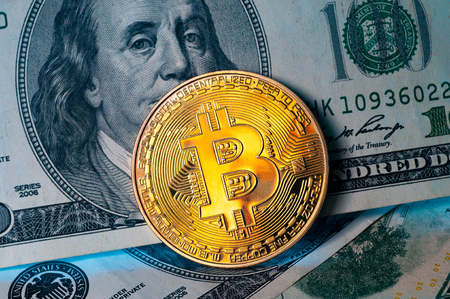 Golden Bitcoin coin on us dollar bills backgroundの写真素材