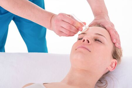 Young Woman receives facial cupping massage facial rejuvenation treatment at acupuncture wellness spaの写真素材