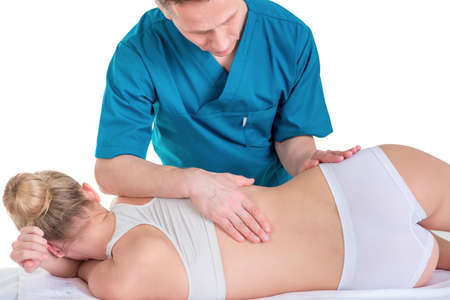 Physiotherapist doing healing treatment on mans back. Therapist wearing blue uniform. Osteopathy....
