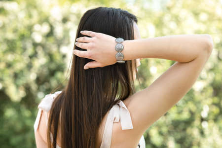 Young woman shows jewelry isolated on spring nature backgroundの写真素材