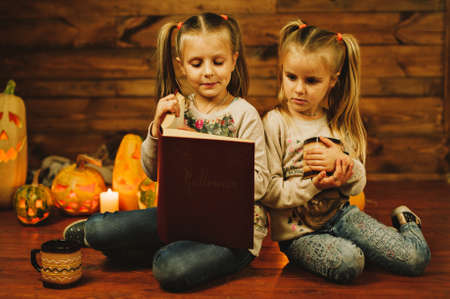 Two girls preparing for the holiday. Night, candles, pumpkin, tales.の写真素材