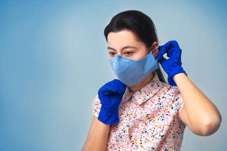 The girl in gloves puts on a medical mask. The concept of coronavirus and covid-19