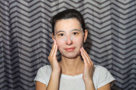 Girl in a cosmetic face mask. Makes homemade beauty treatmentsの写真素材