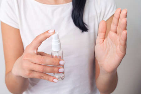 Hand disinfection. Ladys hand takes alcohol disinfectant spray on her hands. to prevent a viral epidemic. Isolated on a white background. Flu Prevention Properly clean and disinfect hands.の写真素材