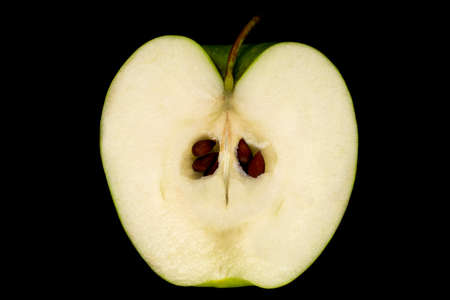 Cut green Apple with pits and peduncle on black backgroundの写真素材