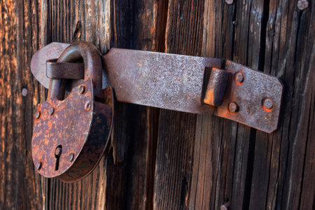 Old rusty padlock on an old wooden door, close-up