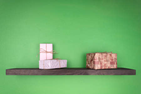 New Year's gifts on the shelf of dark color which is fixed on the wall of green