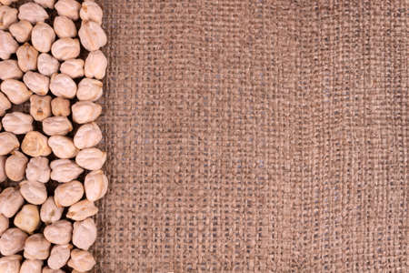 solid fruits of a round form of chickpea ram lie on a dense fabric on the leftの写真素材