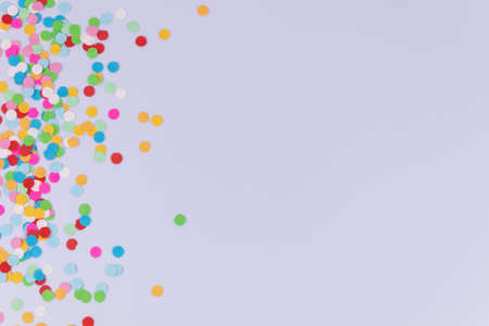 A multicolored round confetti scattered from one side of a photo on white backgroundの写真素材