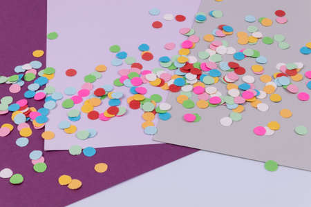 Multicolored colorful  round confetti scattered on several sheets of paper 