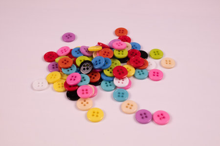many multi-colored buttons are piled in a bunch on a white background