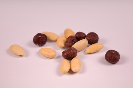 several nuts almonds and hazel on a white background in a chaotic close-upの写真素材