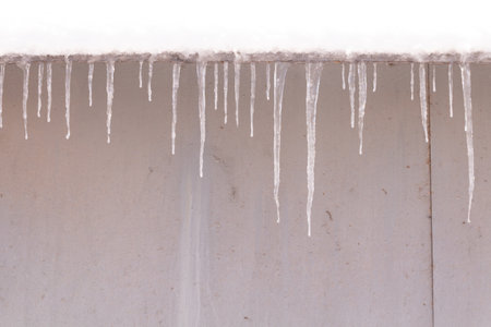 Many small and thin icicles on the edge of the roof