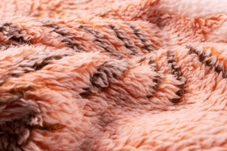 evenly folded blanket with a black pattern in orange with a white cover