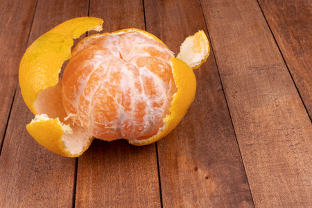 peeled tangerine lies in the skin on the boardsの写真素材