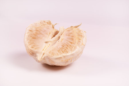 an angled view of a peeled half of a tangerine lying center upの写真素材