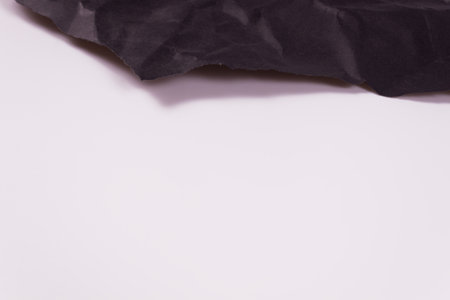 black sheet of crumpled paper at the top of the frame