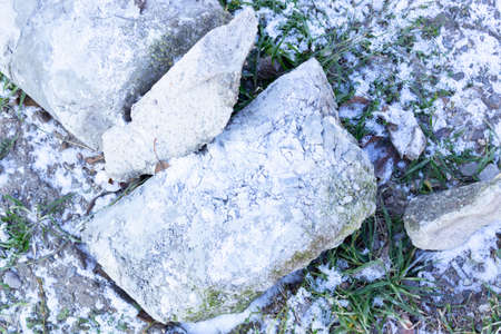 two white blocks lie on frozen greeneryの写真素材