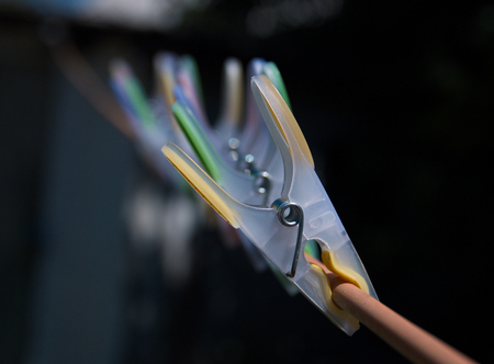 colorful clothespins hanging in a row on clotheslineの写真素材