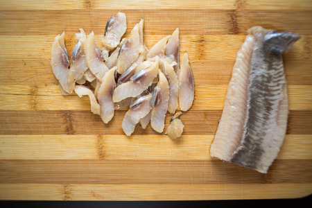 Sliced herring lying on a wooden board.