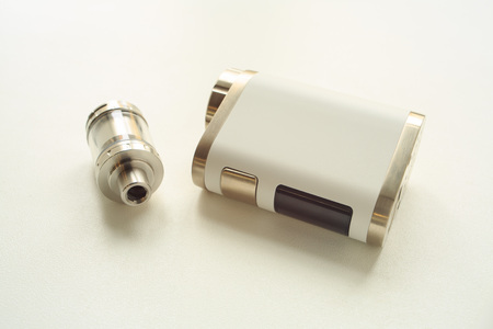 Electronic cigarette and liquid tank on the table. Vaping. ENDS.