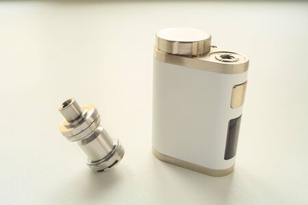 Electronic cigarette and liquid tank on the table. Vaping. ENDS.