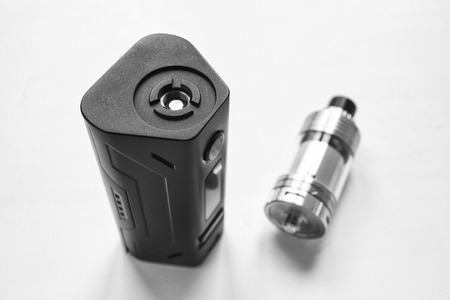 Electronic cigarette and liquid tank on the table. Vaping. Black and white  ENDS.