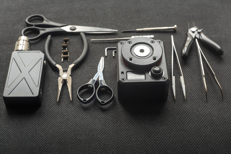 Vape. Tools for repair and maintenance of the electronic cigarette on the black background. Top view.の写真素材