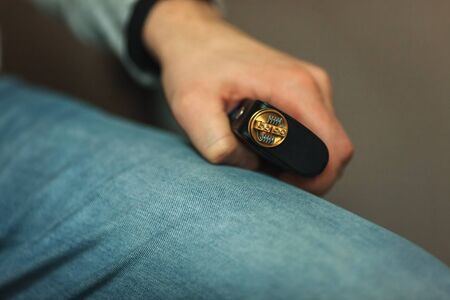 Vape after-sales service of the electronic cigarette. Male hands regulate e-cig coils. Personal vaporizer.の写真素材