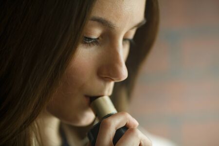 Vaping teenager. Young pretty white girl smoking an electronic cigarette in vape bar. Bad habit.