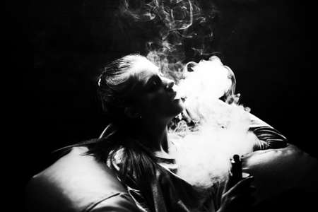 Vaping teenager. Young pretty white caucasian teenage girl with problem skin smoking an electronic...