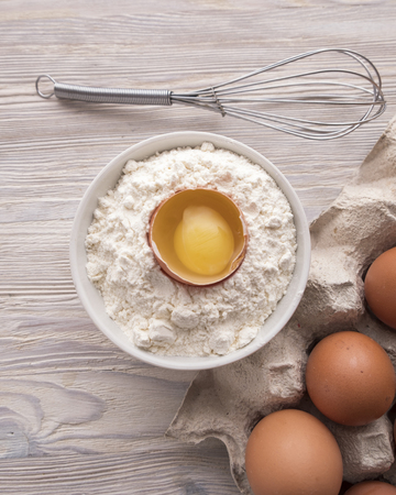 Ingredients for baking: flour, eggs and yolk on a table. Bakery concept. Top viewの写真素材