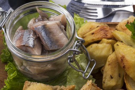 Marinated herring with herbs and onion served with fried potatoes. Selective focus.