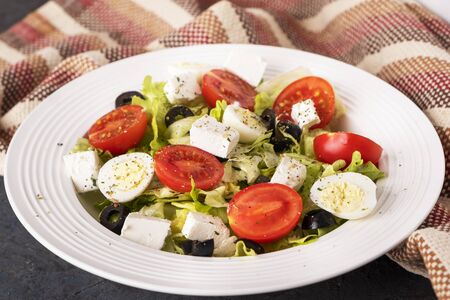 Diet salad with fresh vegetables. Tomatoes, quail eggs, lettuce, cheese and black olives. Healthy food concept.の写真素材