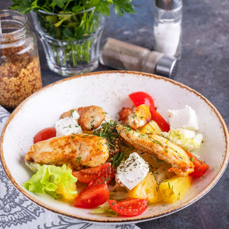 Tasty salad with fried chicken, tomatoes, pineapple, cheese and lettuce.の写真素材