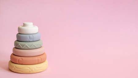 Pyramid toys. Children's silicone pyramid on pink background. Text space