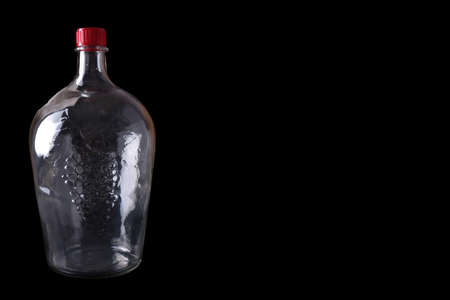 Big empty glass bottle isolated on black. Copy spaceの写真素材