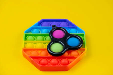 Minsk, Belarus - September 5, 2021: Pop it and simple dimple toys on yellow background. Children's antistress toys.のeditorial素材
