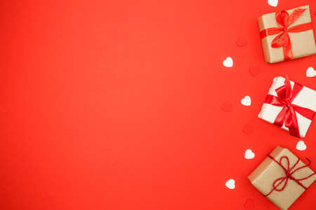 Gift boxes and hearts on red background. Valentine's day concept. Top view, copy spaceの写真素材