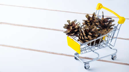 Christmas bumps in a small troley on wooden background. Copy spaceの写真素材