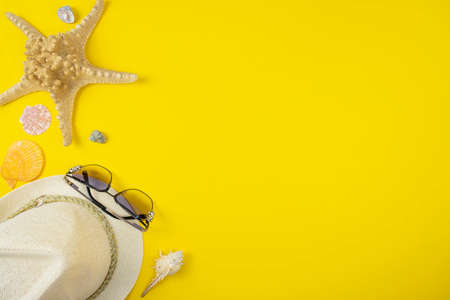 Summer background with sunglasses and beach hat on yellow background. Vacation concept. Space for textの写真素材