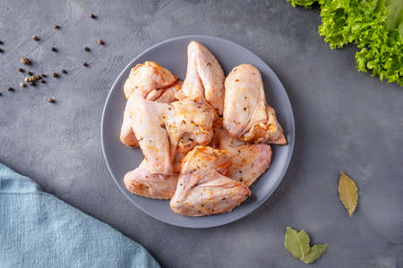 Raw marinated chicken wings on a round plate. Top viewの写真素材