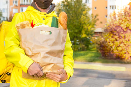 Delivery boy with foods bag in a sunny day. Copy spaceの写真素材