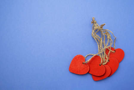 Wooden red hearts on violet background. Celebration concept. Space for textの写真素材