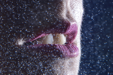 lips with pink lipstick for a splash of water on black background close-upの写真素材
