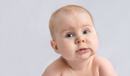 baby infant close-up portrait. looking at camera. on a white towelの写真素材