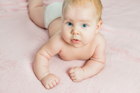 the child lies on stomach on bedの写真素材